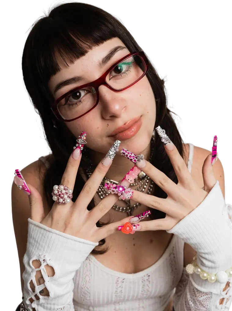 Modelo mostrando unhas longas com strass, charms e estampa de zebra rosa