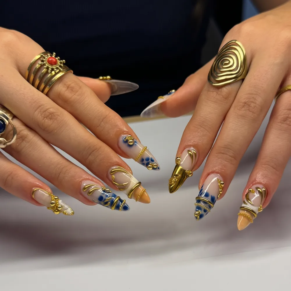 Unhas com gel 3D, charms dourados e detalhes em azul
