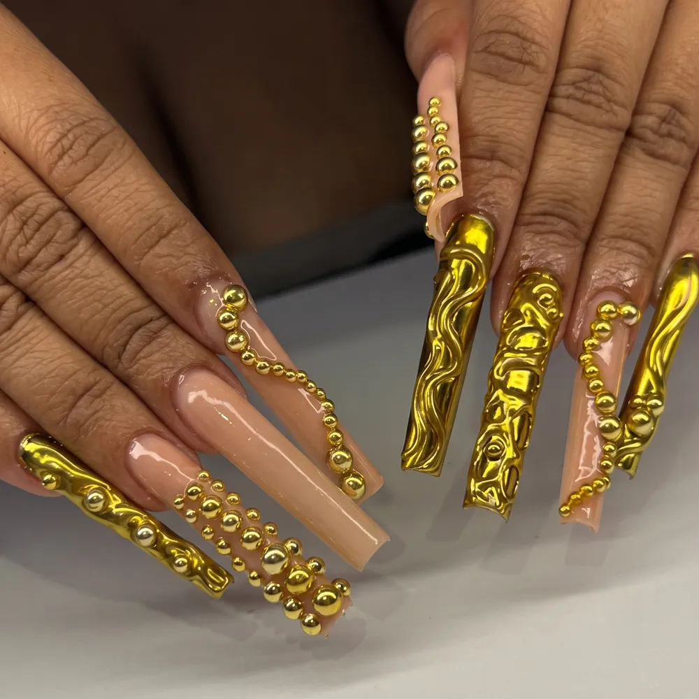 Unhas longas com relevo em cromado dourado e esferas metálicas
